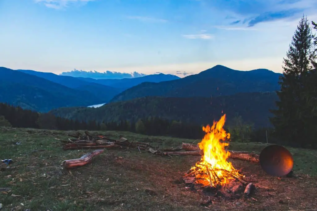 photo of campfire with mountains in background